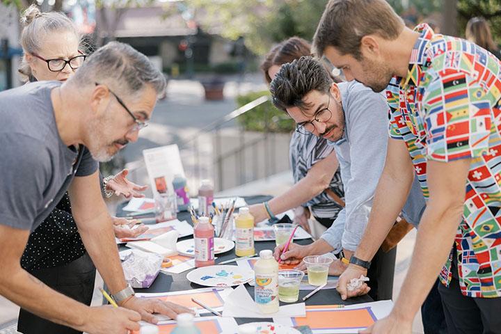 Adults crafting at a long table.